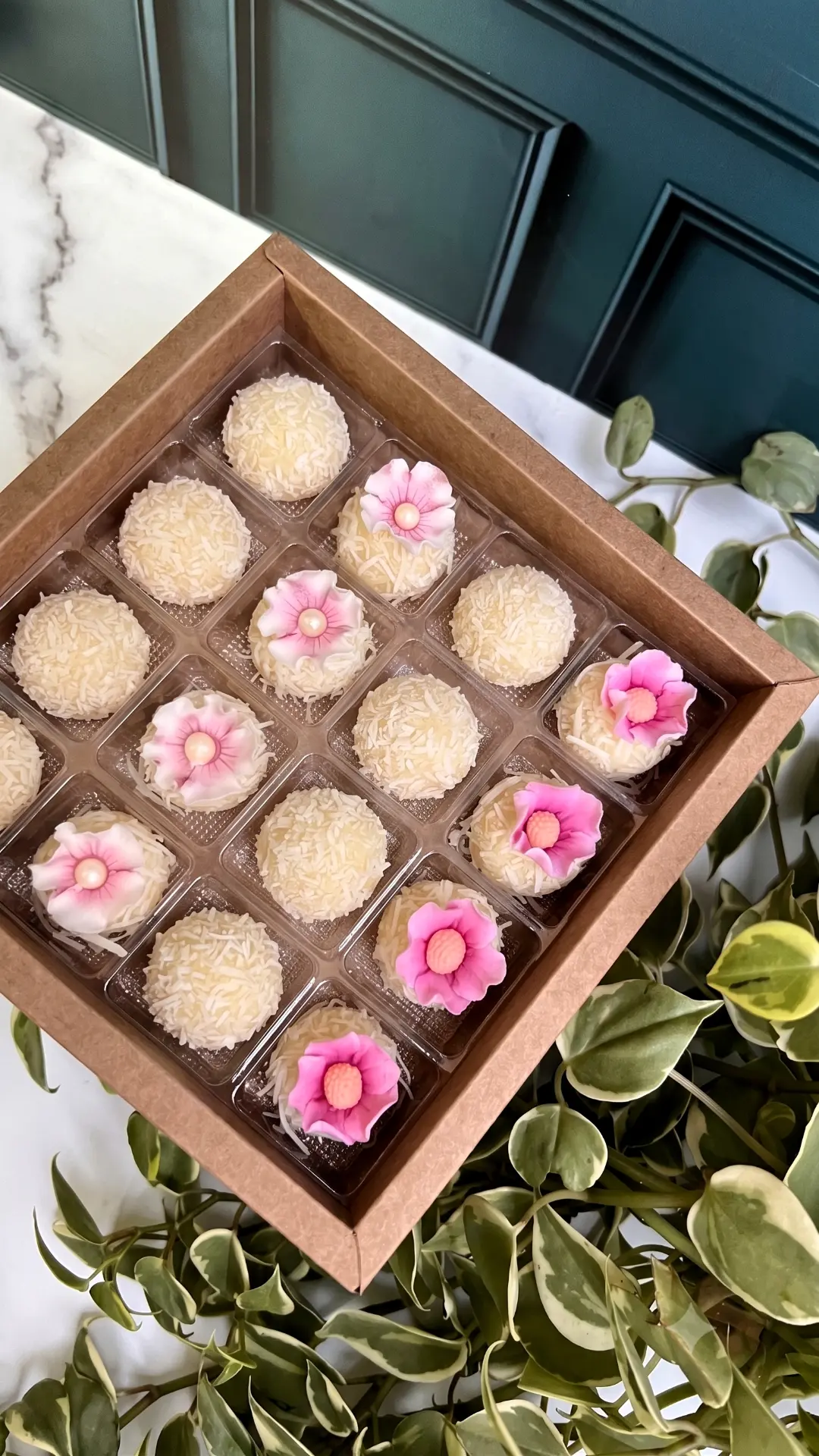 Caixa de brigadeiros de coco com mini flores rosa